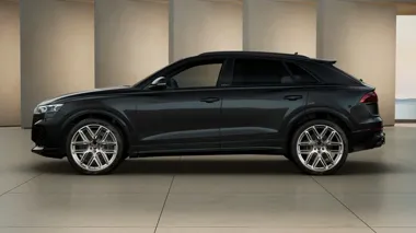 Czarny SUV Audi widziany z boku w nowoczesnym salonie.