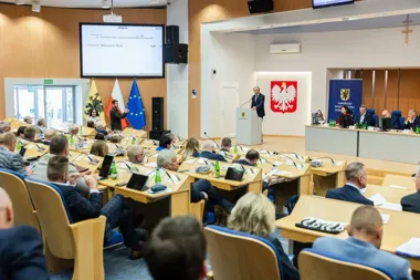 Posiedzenie sejmiku województwa pomorskiego w sali plenarnej z mówcą przy pulpicie i radnymi przy ławkach.